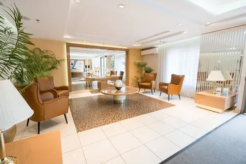 Common lounge with armchairs and broad windows.
