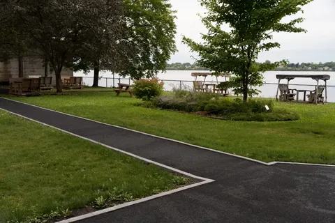Lawn and paved paths beside the river.