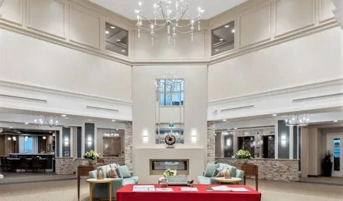 Lobby with sofas, tables, a fireplace and a high ceiling