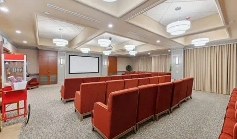 Screening room with rows of red seats facing a projection screen
