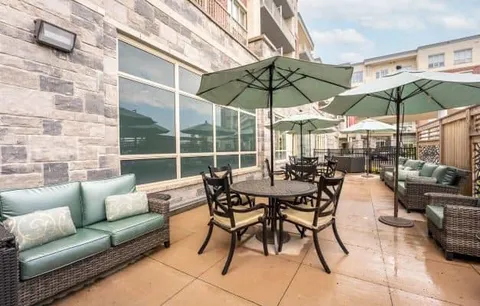 Patio with tables, chairs, umbrellas and wicker sofas