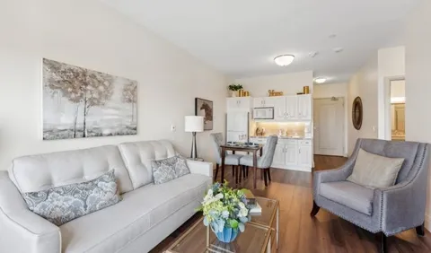 Sitting area with a sofa, armchair, dining table and kitchenette