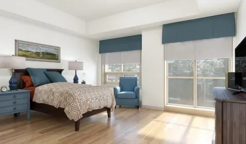 Bedroom with a bed, armchair and large windows