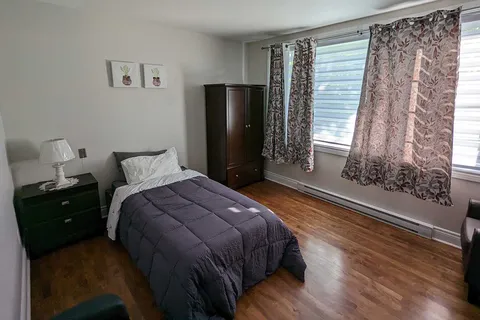Bedroom with a single bed and wood flooring.