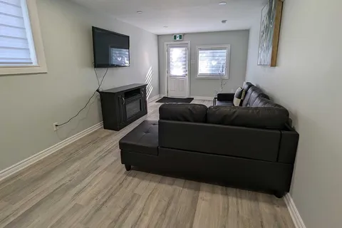 Living room with a sofa, television and electric fireplace.