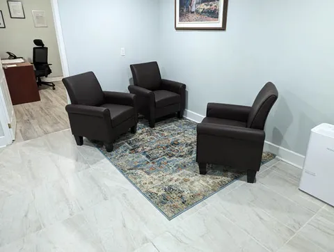 Sitting area with dark armchairs.