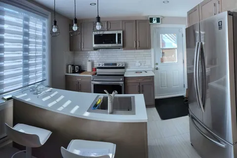 Communal kitchen with a peninsula counter and appliances.