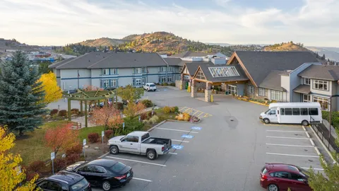 Residence facade and covered entrance viewed across the parking area.