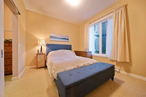 Suite bedroom with a bed, bedside tables and a cushioned bench.
