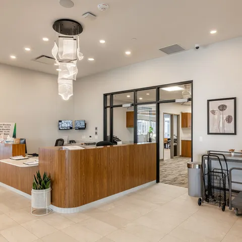 Reception area with counter, chairs and pendant lighting.