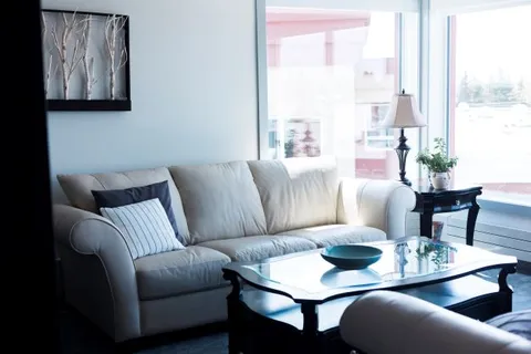 Suite living area with a sofa and coffee table beside a window.