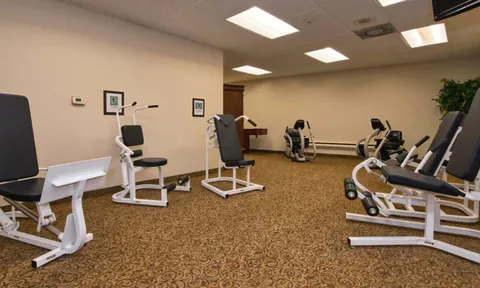 Exercise room with strength machines and stationary bikes.