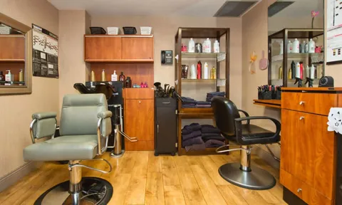 Salon with styling chairs, mirrors and hair dryers.