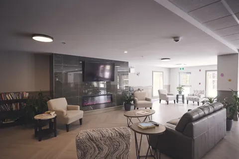 Lounge with sofas, armchairs, bookshelves and large windows.