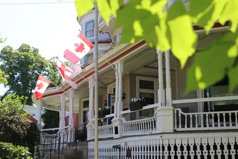 Residence porch with white railings and Canadian flags