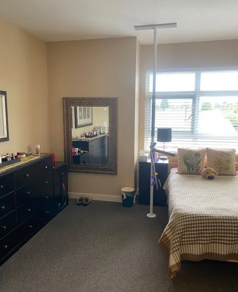 Bedroom with a double bed, a dresser and a wall mirror