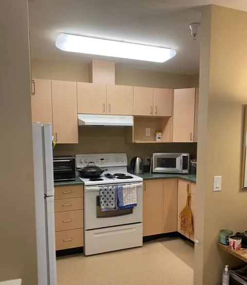 Kitchen with pale cabinets, a stove and a microwave