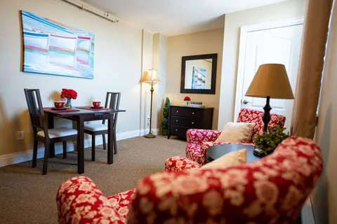 Sitting and dining area with red patterned armchairs and a small table