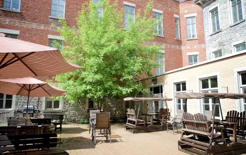 Courtyard terrace with umbrellas, tables and wooden swings.
