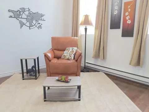 Sitting area with an armchair, coffee table and floor lamp.