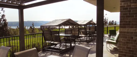 Covered terrace with chairs, tables and views across trees