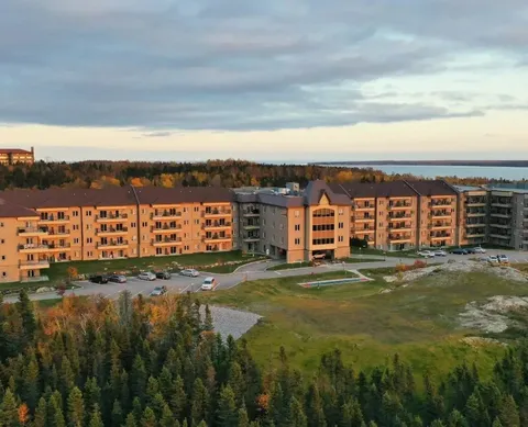 Aerial view of a multi-storey residence beside lawns and trees