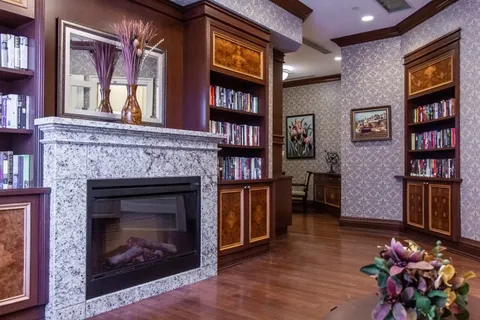 Stone fireplace between wooden book shelves beneath a wall mirror