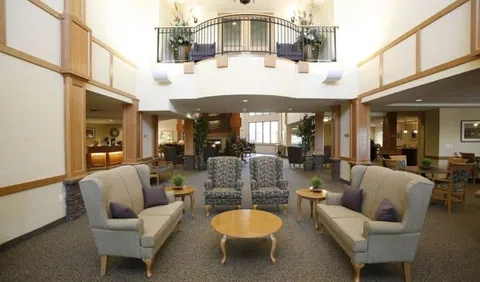 Atrium with armchairs, side tables and an upper-floor balcony