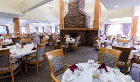 Dining room with set tables around a stone fireplace