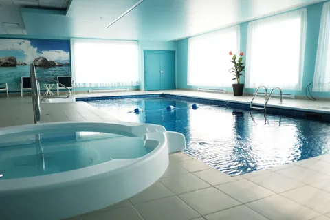 Indoor swimming pool and spa with tiled surrounds.