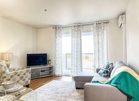 Suite living room with a television and patio door.
