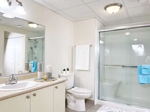 Bathroom with a vanity, toilet and glass shower enclosure.