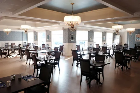 Dining room with tables, chairs and ceiling lights.