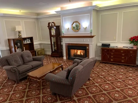 Fireside lounge with sofas, coffee tables and a grandfather clock.