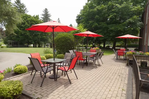 Paved patio with red chairs, tables and red umbrellas