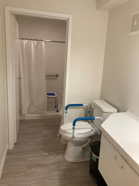 Bathroom with a sink, toilet and shower with a seat