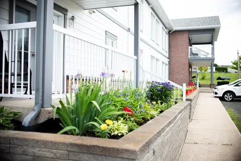 Raised flower bed beside a walkway and the residence balconies.
