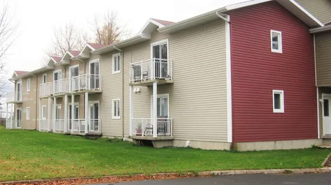 Two-storey residence with balconies and a lawn.