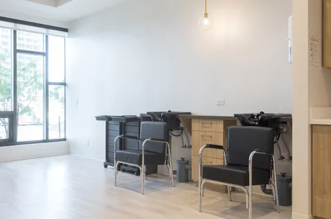 Hair salon with chairs and wash basins.