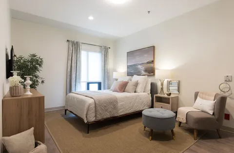 Furnished suite bedroom with a bed and armchair.