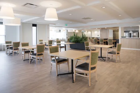 Dining room with square tables and a serving counter.