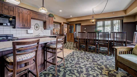 Cafe area with bar stools, wooden cabinets and a long table