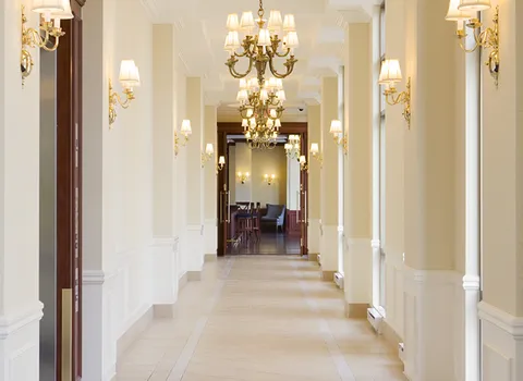 Hallway with chandeliers and cream-coloured walls