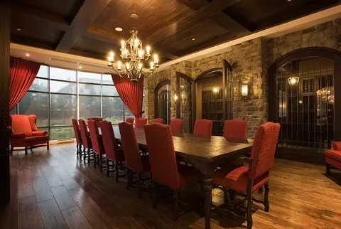 Dining room with a long wooden table and red upholstered chairs