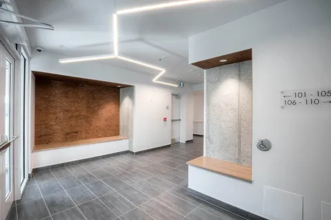 Entrance hall with a bench and wood-panelled wall.