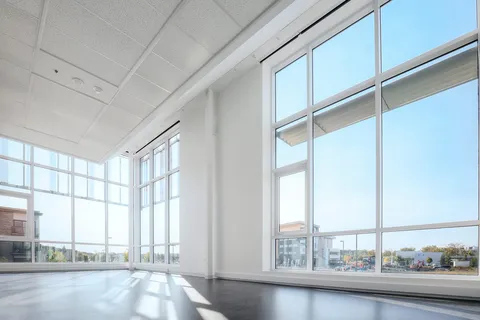 Empty multipurpose room with tall windows.