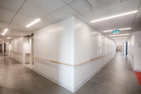 Residence corridor with handrails and recessed lighting.