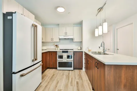 Kitchen with white cabinets and a wood-fronted island.