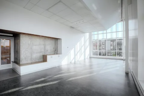 Multipurpose room with broad windows and patterned flooring.