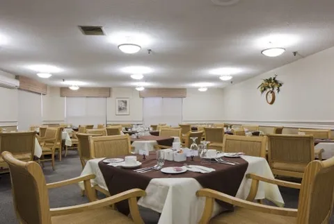Dining room with tables, upholstered chairs and place settings